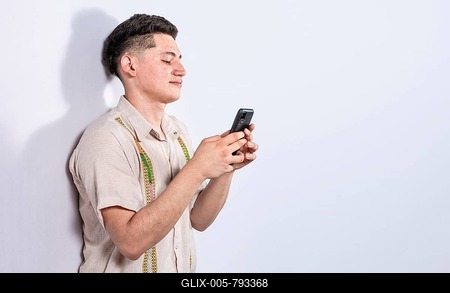 Handsome guy happy with his cell phone on isolated backgrounds, young latin man happy with his cell phone isolated, man on white background texting with his cell phone-stock-foto
