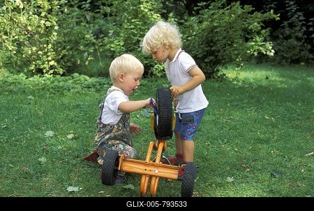 Two three year old boys repairng tricycle MR-stock-foto