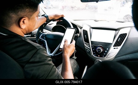 Person holding the cell phone and with the other hand the steering wheel, Distracted driver using the cell phone while driving, Man using his phone while driving, Concept of irresponsible driving-stock-foto