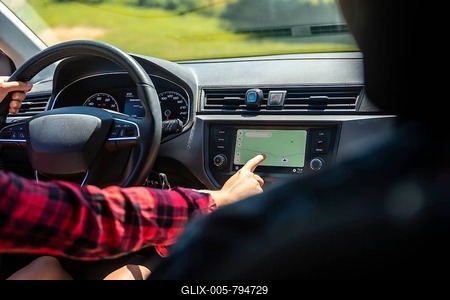 Woman driving a car while interacting with the navigation system on the dashboard's touchscreen display, ensuring accurate route guidance-stock-foto