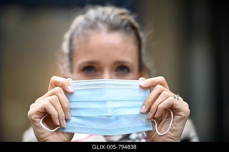 Woman putting on a face mask, portrait, corona crisis, Stuttgart, Baden-Württemberg, Germany-stock-foto