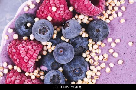 Close up of healthy yogurt and fruit smoothie bowl decorated with raspberry, blueberry and puffed quinoa grain-stock-foto