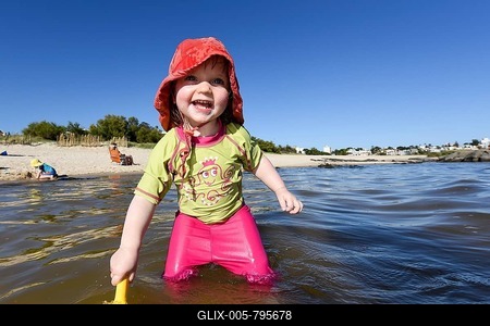 Toddler with sunhat in the water, Rambla beach, Montevideo, Uruguay-stock-foto