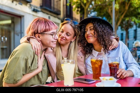 Cute female friends embracing while drinking sodas and eat snacks in an outdoor terrace-stock-foto