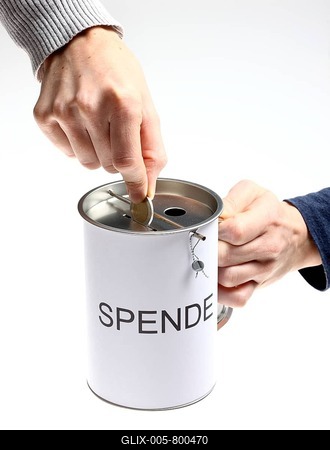 Hands with a donation box labeled Spende, German for donation, with slots for coins and bills, with a security seal to protect against unlawful opening-stock-foto