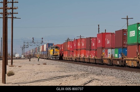 An eastbound Union Pacific freight train carrying shipping containers waits on a siding for a westbound train, also carrying shipping containers, to pass, Niland, California, USA-stock-foto