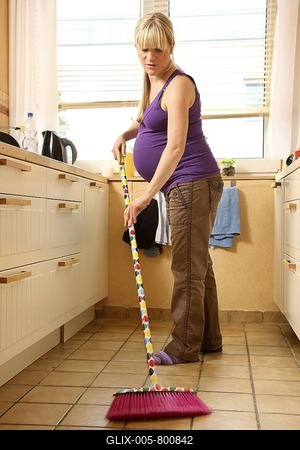 Pregnant woman, 9th month, at home, doing light housework, cleaning the kitchen floor-stock-foto