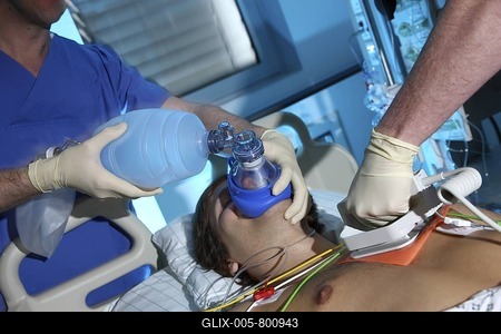 Case of emergency at an intensive care unit, cardiovascular arrest, patient is being given artificial respiration by hand, resuscitation with a heart defibrillator is being arranged, hospital-stock-foto