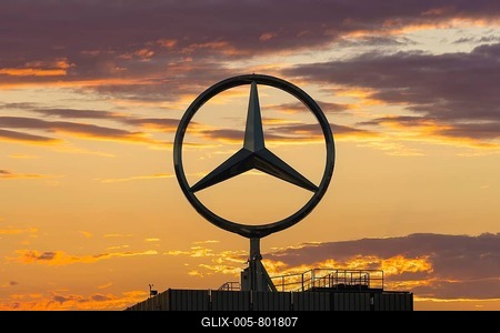 A Mercedes star in front of an orange-coloured sunrise sky with clouds, Stuttgart-Untertürkheim, Baden-Württemberg, Germany-stock-foto
