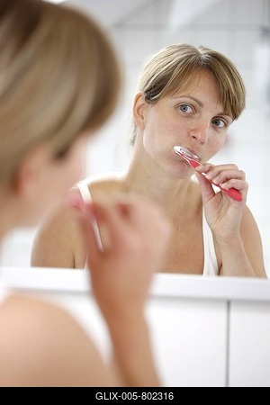 Young woman brushing her teeth in a bathroom-stock-foto