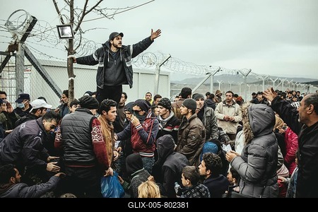Idomeni refugee camp on the Greece Macedonia border, refugees waiting at a checkpoint, a man translates the official informations, Idomeni, Central Macedonia, Greece-stock-foto