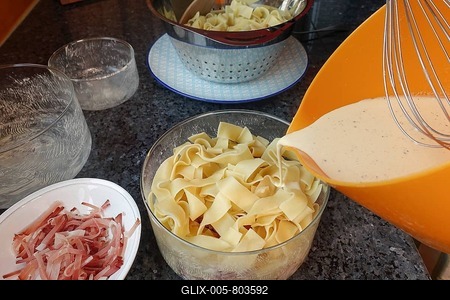 Swabian cuisine, preparing pasta casserole with Black Forest ham, filling casserole dish with pasta and egg-cream mixture, round glass baking dish, mixing bowl, snow beesne, oven dish, food photography, studio, Germany-stock-foto