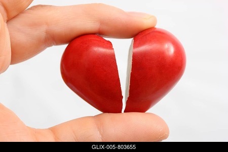 Hand holding a broken heart, symbolic image for heart disease, heart attack, a diseased heart, cardiology or heartache-stock-foto