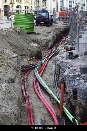 Installation of various cables in a building site, power lines and telecommunication cables, some in protective tubes, placed in the ground-stock-foto