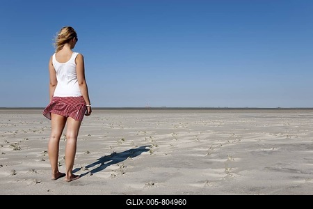 Young woman, 20-25 years, looking in the distance on a sunny summer day on the beach of St Peter Ording, North Sea, North Friesland, Schleswig-Holstein, northern Germany, Germany, Europe-stock-foto