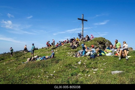 Mountain hikers rest at the summit cross of the Hoher Ifen mountain, near Hirschegg, Kleinwalsertal, Vorarlberg, Allgäuer Alps, Austria-stock-foto