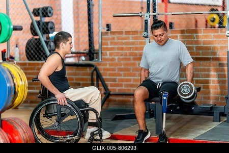 Two men with disabilities, one using a wheelchair and another with a prosthetic leg, engaging in fitness activities and supporting each other during a workout session at the gym-stock-foto