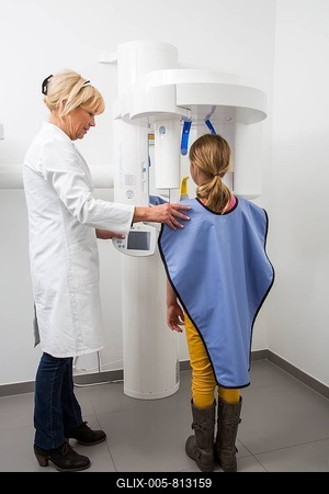 Girl being prepared for an x-ray of her teeth, wearing a lead vest as radiation protection, Germany-stock-foto