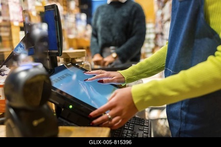 Salesperson using a touch screen cash register in an organic supermarket, selling natural and gluten free products-stock-foto