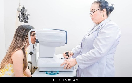 Optometrist checking the eyesight of a patient with an autorefractor. Oculist doing eye exam to female patient-stock-foto