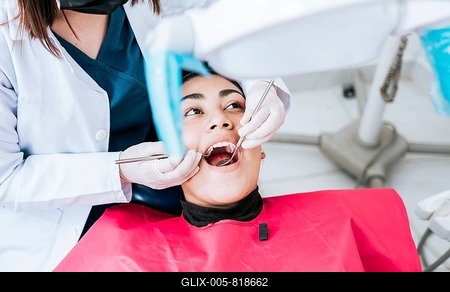 Top view of dentist doing cleaning to female patient lying down. Dentist doctor examining mouth to patient lying on chair, Female dentist examining mouth to patient lying down-stock-foto