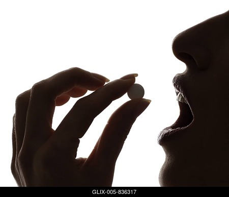 Woman taking a pill, silhouette-stock-foto