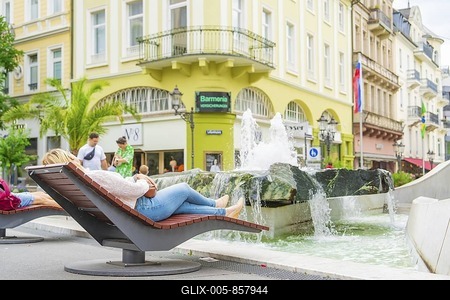 People relaxing on deckchairs by a fountain in an urban environment, Baden Baden, Germany-stock-foto