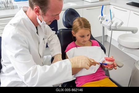 Dentist showing a girl the proper use of a toothbrush, Germany-stock-foto