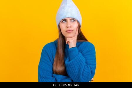 Thinking woman with many ideas with copyspace over yellow background, wearing blue wool sweater-stock-foto