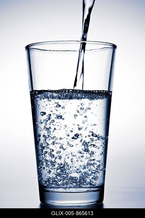 Water is being poured into a glass-stock-foto