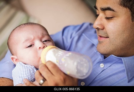 Happy hispanic father bottle feeding his very content son-stock-foto