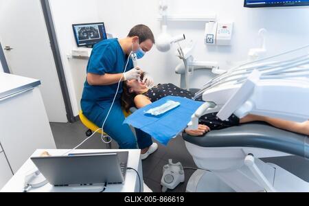 Dental clinic, dentist performing a 3d scan to the patient lying in a modern operating room-stock-foto