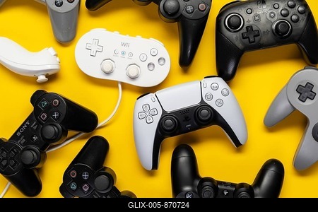 Different generations of Playstation and Nintendo game controllers, against a plain yellow background, top view-stock-foto