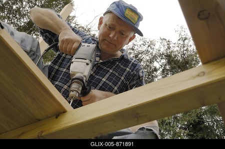 Man drilling holes into a wooden beam-stock-foto