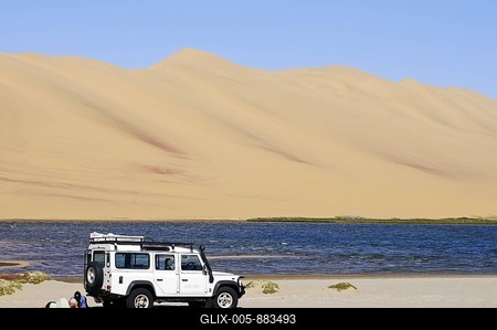 Men with a Landrover Defender off-road vehicle in the wetlands of Sandwich Harbour, Namib-Naukluft National Park, Skeleton Coast National Park, Namib Desert, Namibia, Africa-stock-foto