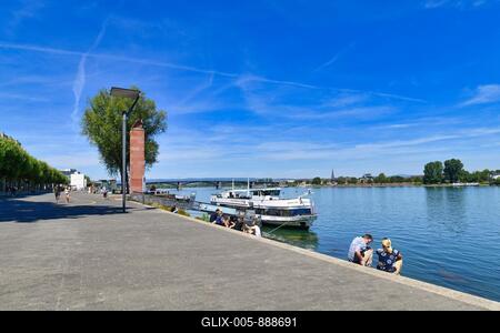 Mainz, Germany, July 2020: Rhine promenade with cruise ship and relaxing people on sunny summer day-stock-foto