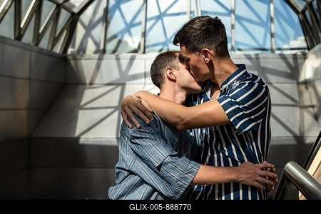 Romantic gay couple embracing and sharing a kiss in a modern architectural setting. Soft light and geometric shadows create an intimate and stylish urban moment filled with love and connection-stock-foto