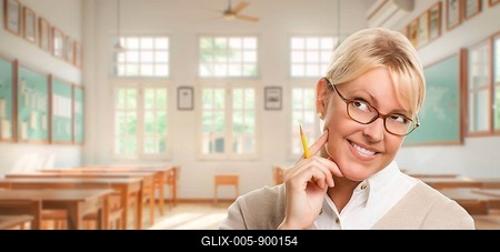 Pretty teacher or student holding pencil standing in her classroom-stock-foto