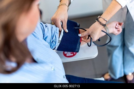 Pharmacist measures a womans blood pressure in a pharmacy clinic, providing routine cardiovascular screening and preventive care using modern equipment for wellness monitoring-stock-foto