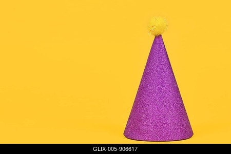 Glittering purple party hat on yellow background with copy space-stock-foto