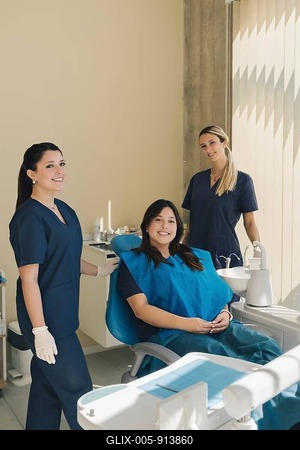 Portrait of three women, dentist, assistant and patient in a dental office smiling and looking at camera. Dental health concept-stock-foto
