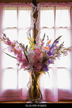Glass vase with silk flowers on the window sill of an old reconstructed 1983 Canadiana cottage style residential log home, Quebec, Canada-stock-foto