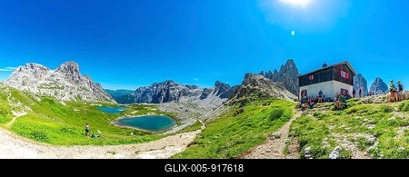 Tourists enjoying breathtaking views while hiking near the tre cime di lavaredo peaks and mountain hut in the italian dolomites during summer. Laghi dei Piani-stock-foto