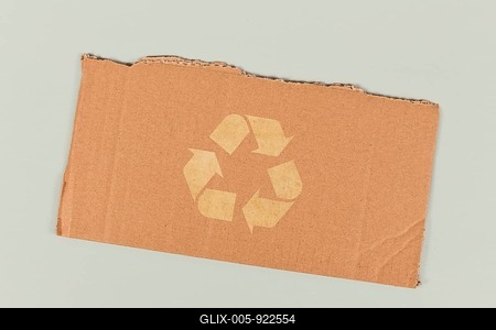Red recycling arrow symbol on piece of cardboard-stock-foto