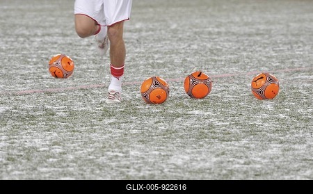 Warm-up training with orange footballs for the winter on snow-covered pitch-stock-foto