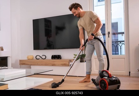 Man using vacuum to clean the living room in the house sharing housework-stock-foto