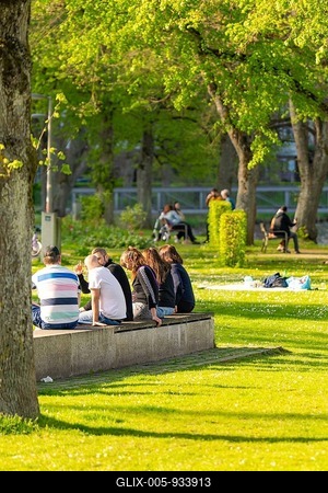 People sitting and relaxing in a sunny park under shady trees, Nagold, Black Forest, Germany-stock-foto