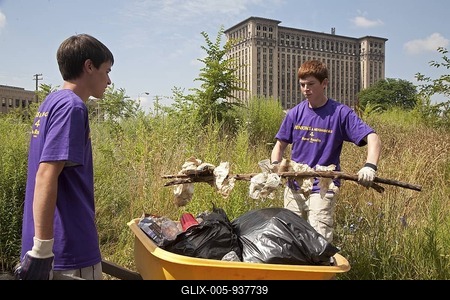High school aged volunteers from St. Mary of the Hills Catholic church in Rochester Hills clean trash and debris from an alley in Detroit's Corktown neighborhood, Detroit, Michigan, USA-stock-foto