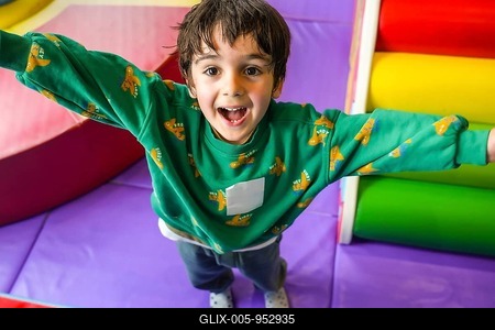 Preschooler enjoying playtime in colorful indoor playground, expressing pure happiness and excitement-stock-foto
