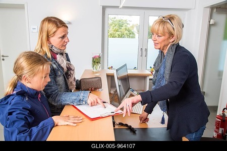 Patients filling in a form at the reception of a dental office, Germany-stock-foto